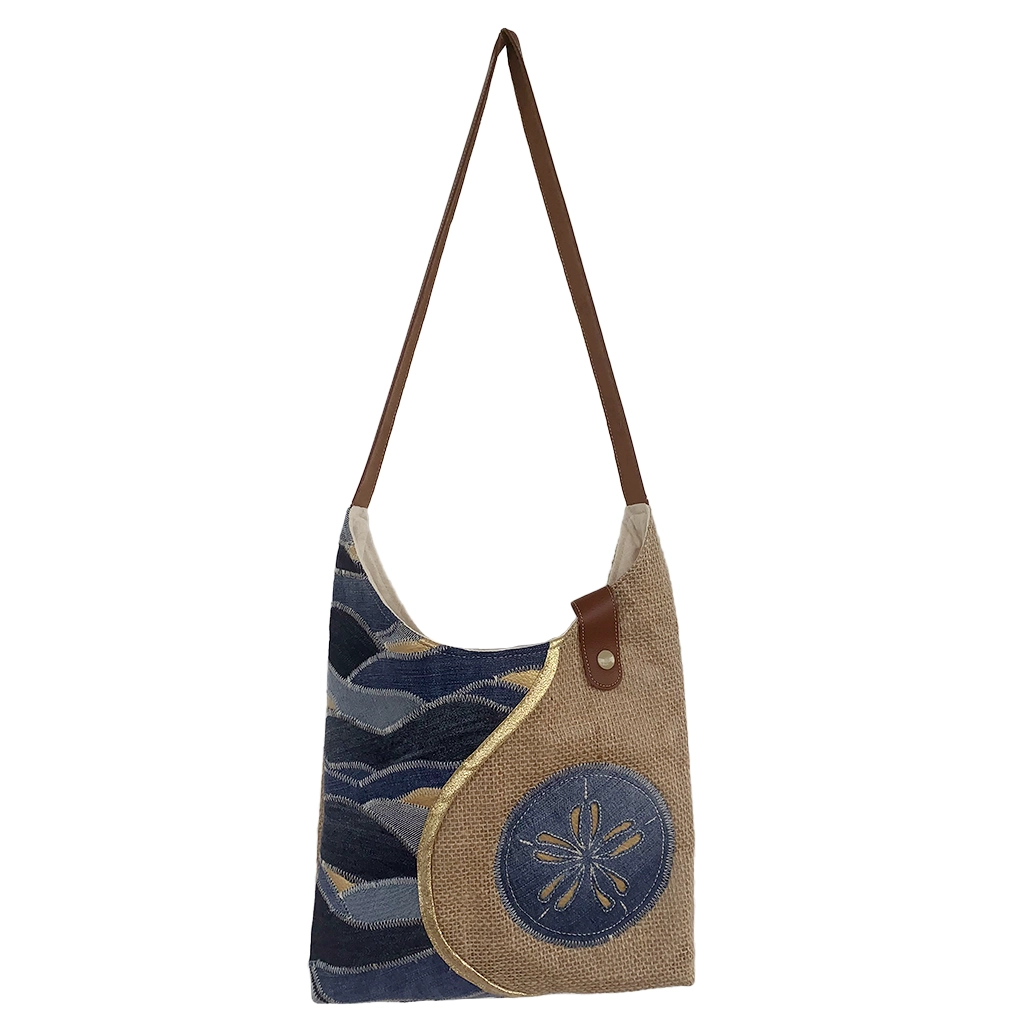 Vue de face du sac KISANDOL en jute, jean et simili cuir avec appliqué dollar des sables, fait main en Guadeloupe.