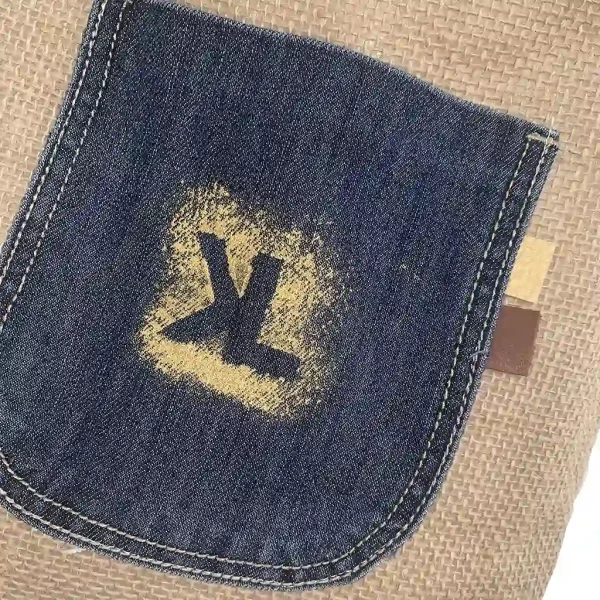 Dos du sac KISANDOL en toile de jute avec poche en jean brut et logo KL peint à la main.