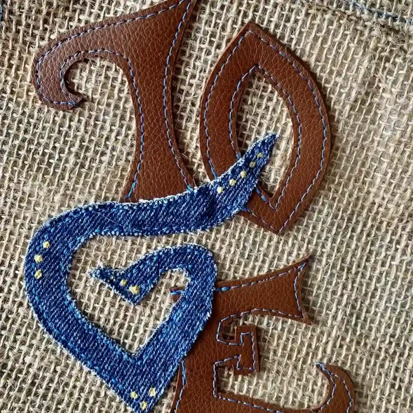 Besace artisanale Krokilove en toile de jute avec appliqué LOVE en jean bleu et finitions simili cuir camel.