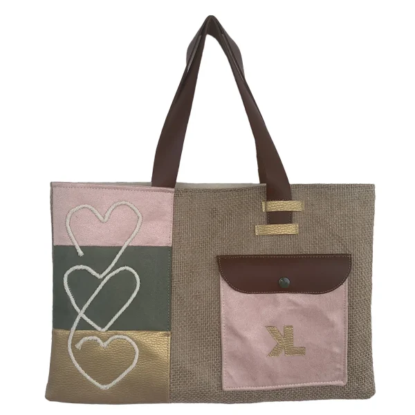 Vue de face du sac cabas artisanal KUBÉA en jute, suédine et simili cuir, avec broderie cœur et poche contrastée, fait main en Guadeloupe.