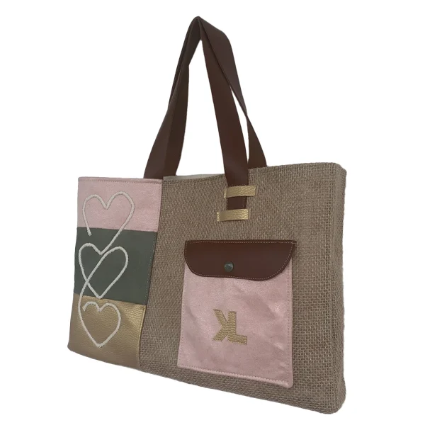 Vue de face du sac cabas artisanal KUBÉA en jute, suédine et simili cuir, avec broderie cœur et poche contrastée, fait main en Guadeloupe.