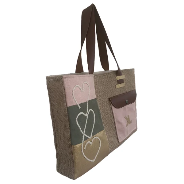 Vue de face du sac cabas artisanal KUBÉA en jute, suédine et simili cuir, avec broderie cœur et poche contrastée, fait main en Guadeloupe.