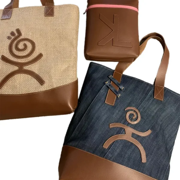 Sac cabas KYDRO en toile de jute beige et simili-cuir camel, motif spiralé marron, sur fond orangé façon coucher de soleil antillais.
